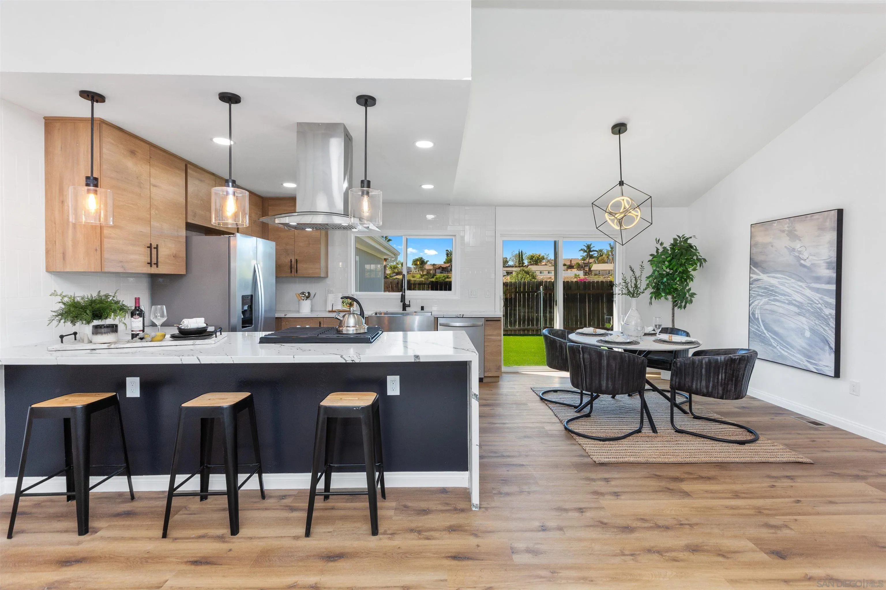 12694 Jackson Heights Drive El Cajon, CA 92021 - Photo 11 of 29 a room with stainless steel appliances kitchen island granite countertop a dining table chairs and a wooden floor