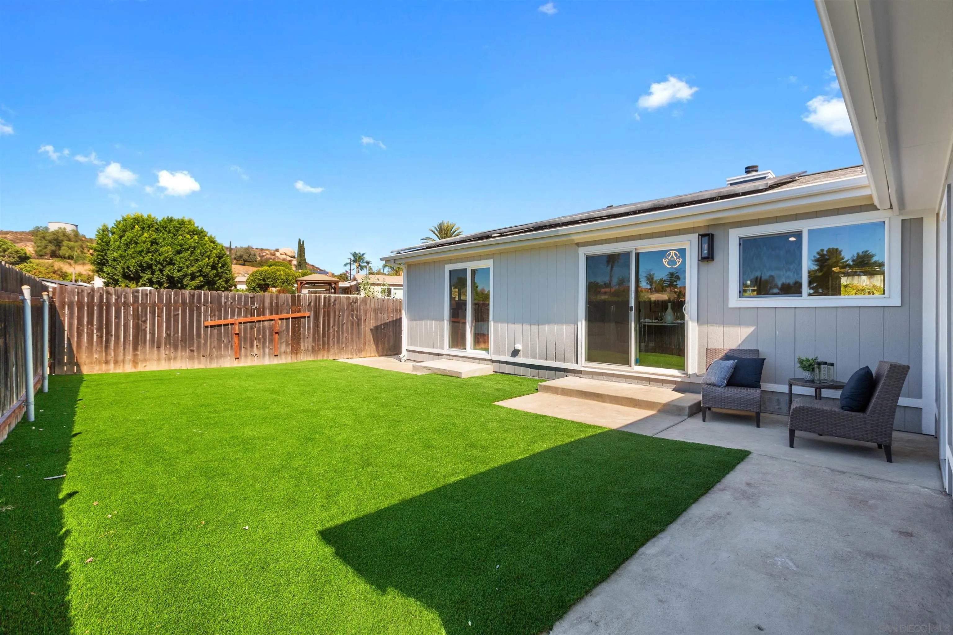 12694 Jackson Heights Drive El Cajon, CA 92021 - Photo 23 of 29 a view of a backyard with couches plants and large tree