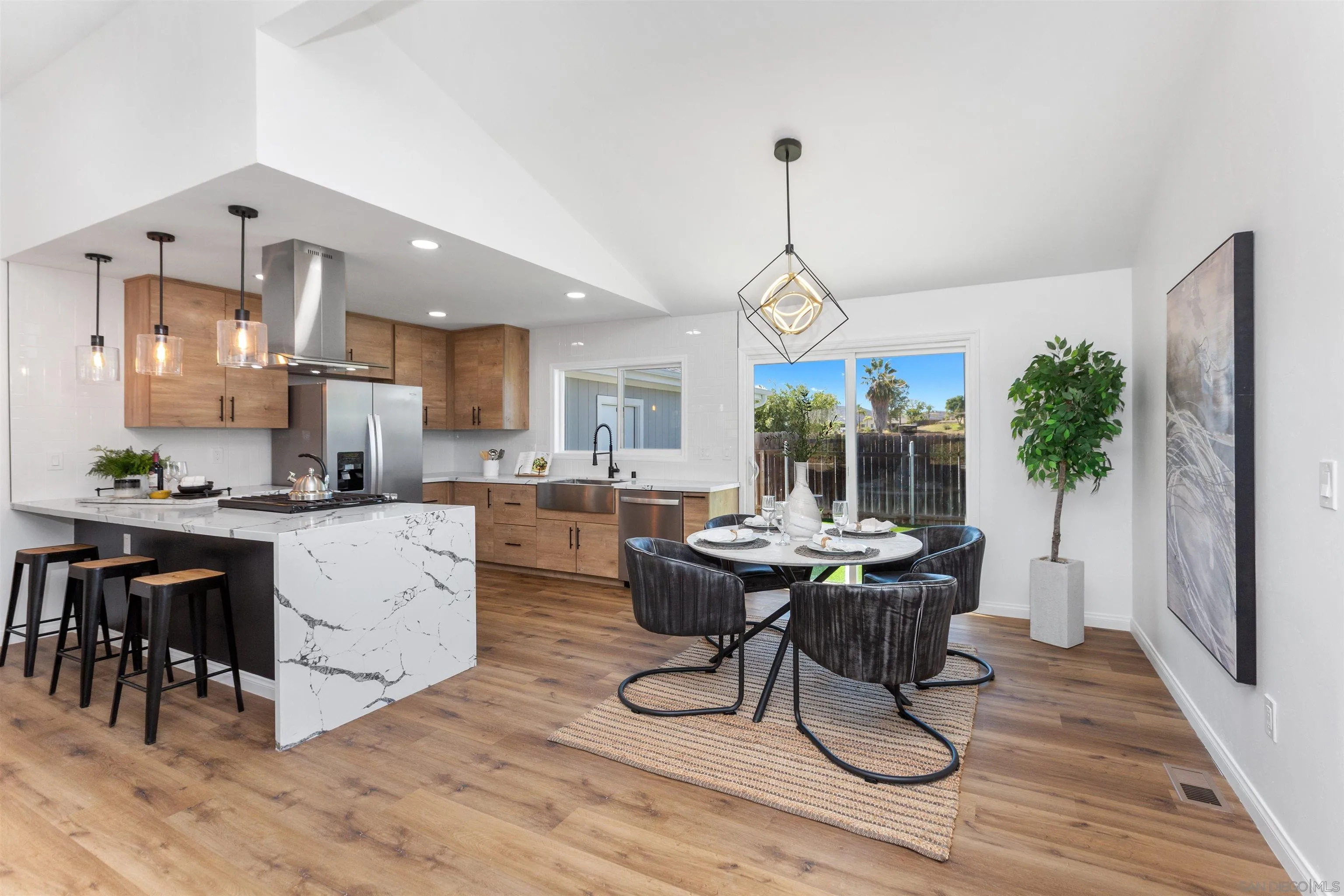 12694 Jackson Heights Drive El Cajon, CA 92021 - Photo 8 of 29 a dining room with wooden floor a chandelier a wooden table and chairs