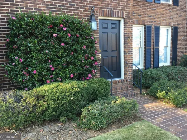 a view of a house that has a flower garden