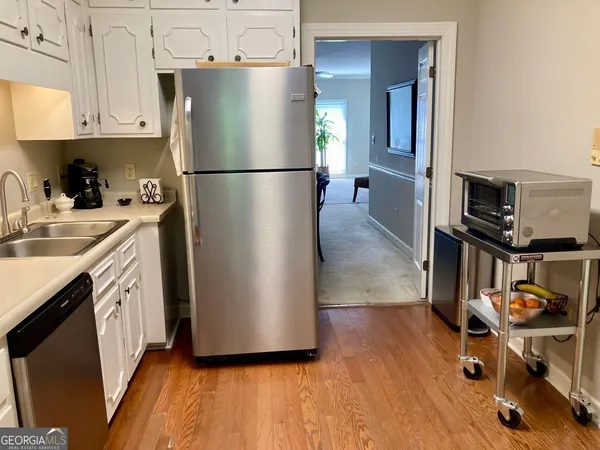 a kitchen with stainless steel appliances granite countertop a refrigerator a stove and a sink