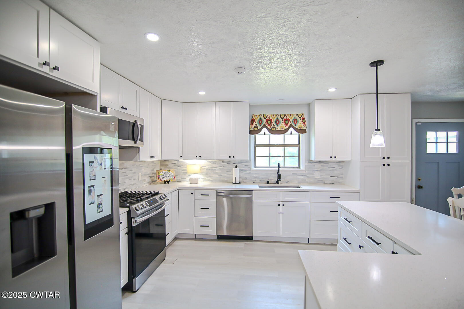 1374 Mifflin Road Jackson, TN 38301 - Photo 8 of 23 a large kitchen with cabinets stainless steel appliances and a chandelier