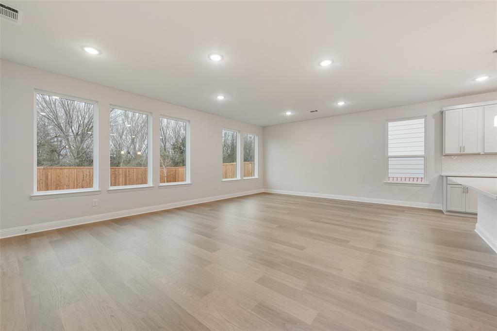 1013 Canoe Way Crowley, TX 76036 - Photo 11 of 26 an empty room with wooden floor and windows