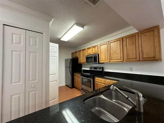 a kitchen with stainless steel appliances granite countertop a sink stove and microwave