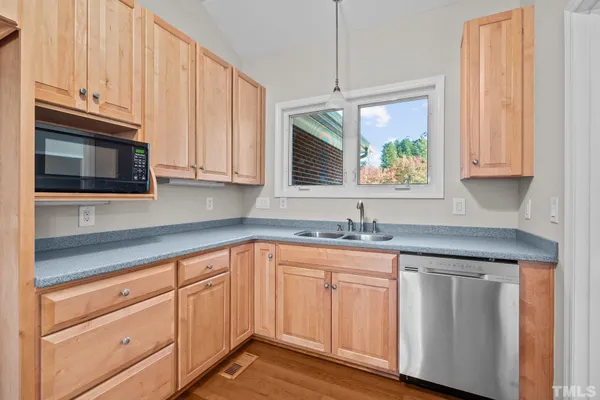 a kitchen with granite countertop white cabinets stainless steel appliances and a sink