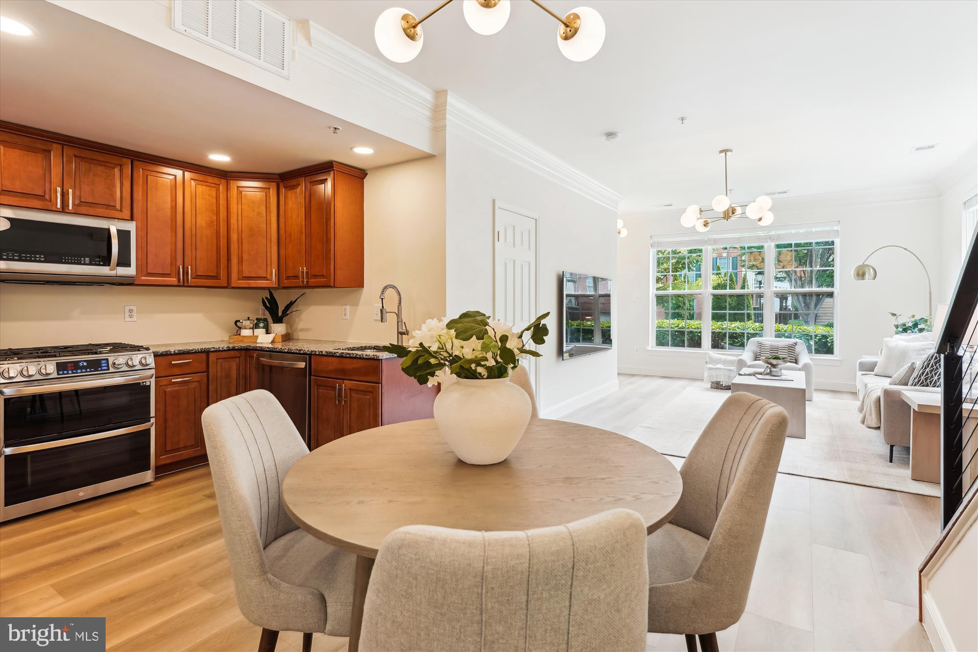 604 Highland Ridge Avenue, Unit 100 Gaithersburg, MD 20878 - Photo 7 of 46 a kitchen with stainless steel appliances granite countertop a stove a dining table and chairs with wooden floor