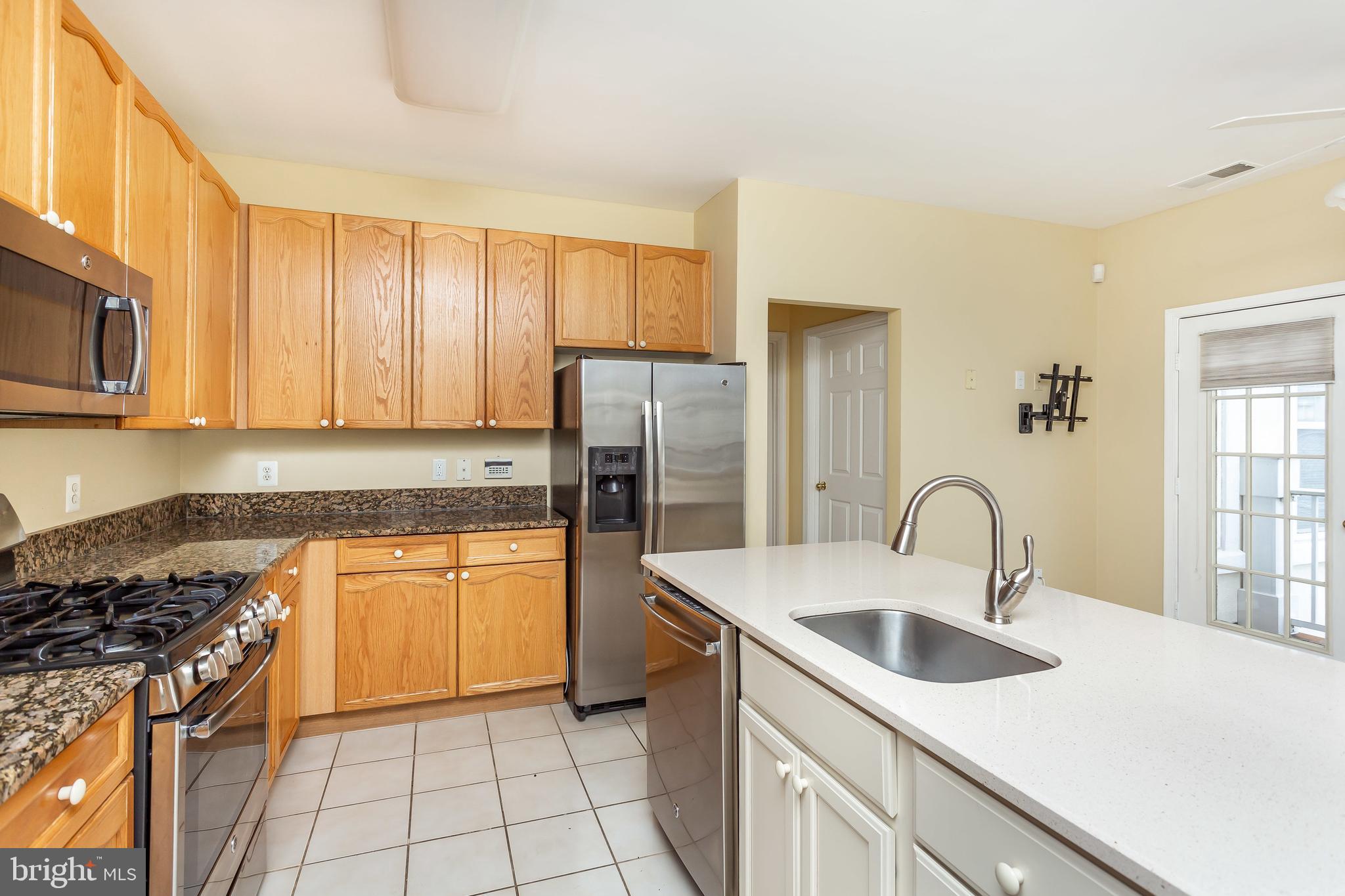 52 Barbican Way, Unit 52 Baltimore, MD 21208 - Photo 11 of 29 a kitchen with stainless steel appliances granite countertop a sink a stove a refrigerator cabinets and a window