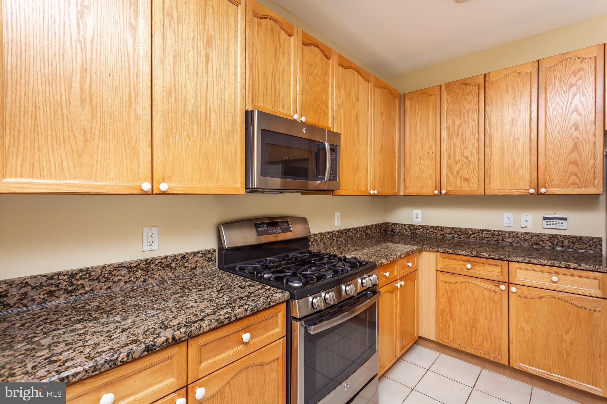 52 Barbican Way, Unit 52 Baltimore, MD 21208 - Photo 12 of 29 a kitchen with granite countertop white cabinets and stainless steel appliances