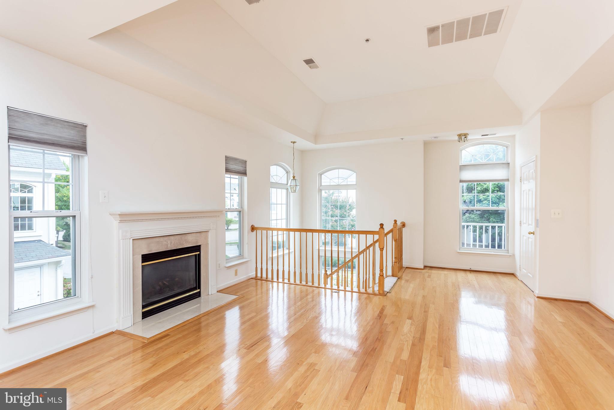 52 Barbican Way, Unit 52 Baltimore, MD 21208 - Photo 5 of 29 a view of livingroom with furniture a fireplace wooden floor and windows