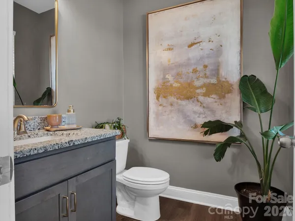 a bathroom with a granite countertop sink a toilet and a mirror