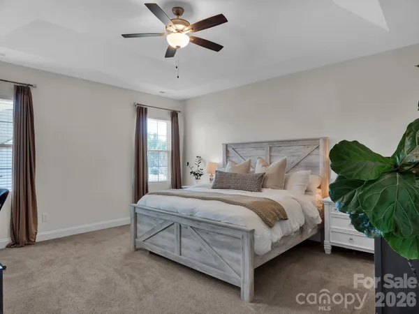 a bedroom with a bed chandelier and a window