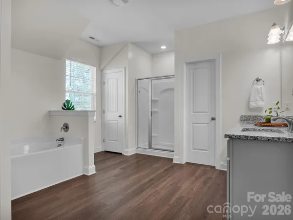 a bedroom with a bed potted plant on a dresser and a chandelier
