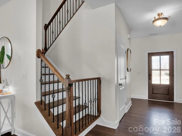 a view of staircase with railing and a chandelier