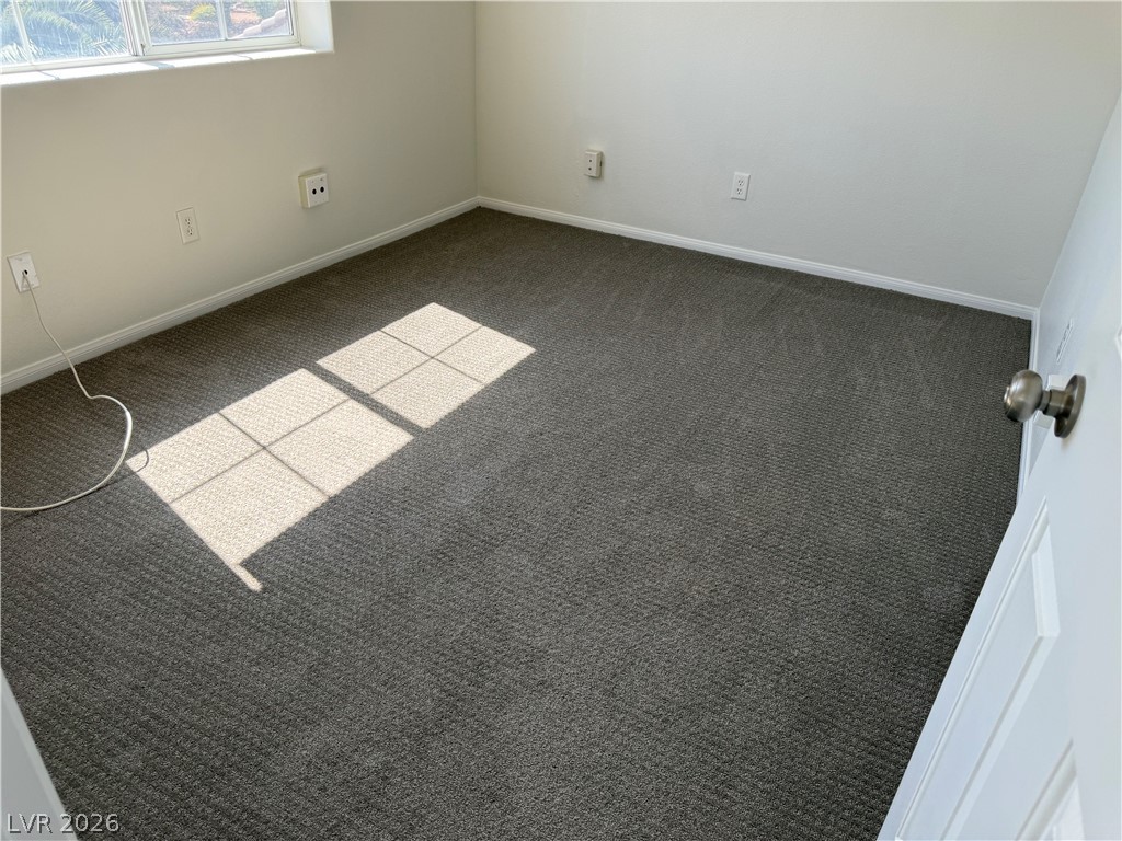 1141 Cathedral Ridge Street Henderson, NV 89052 - Photo 42 of 77 This spacious room offers ample natural light and a clean, comfortable carpeted floor.
