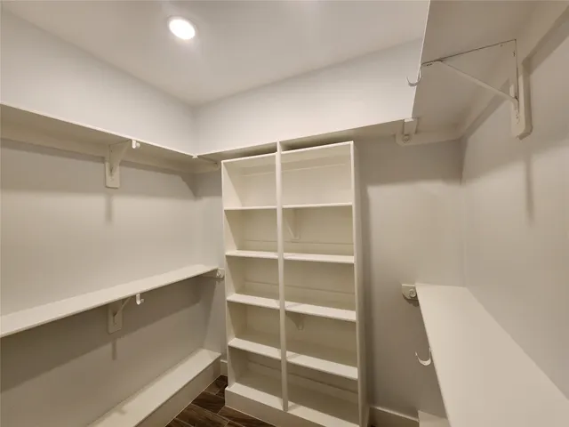 a view of walk in closet with empty racks