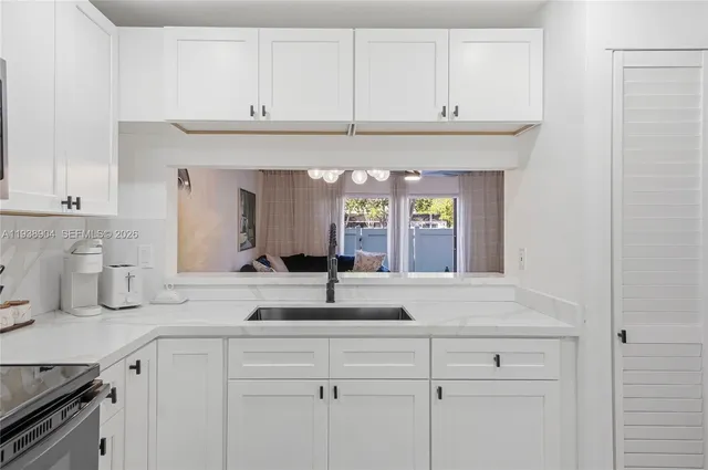 a sink with white cabinets