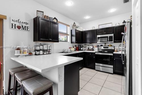 3772 Southeast 2nd Drive, Unit 3772 Homestead, FL 33033 - Photo 9 of 36 a kitchen with stainless steel appliances a stove sink microwave and refrigerator