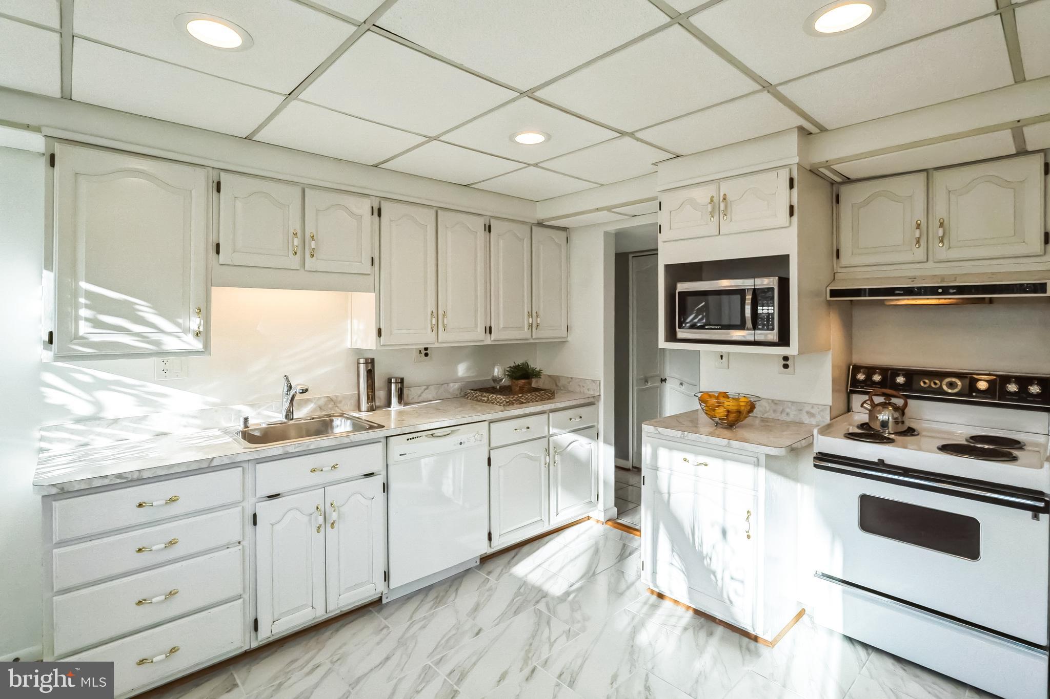 2215 Solmar Drive Silver Spring, MD 20904 - Photo 17 of 34 a kitchen with granite countertop white cabinets and white appliances