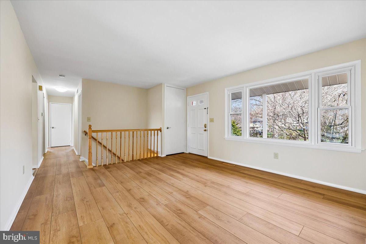 11924 Fernshire Road Gaithersburg, MD 20878 - Photo 6 of 74 a view of an empty room with wooden floor and a window