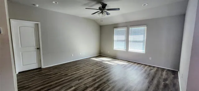 wooden floor in an empty room with a window