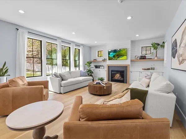 a living room with furniture fireplace and a large window