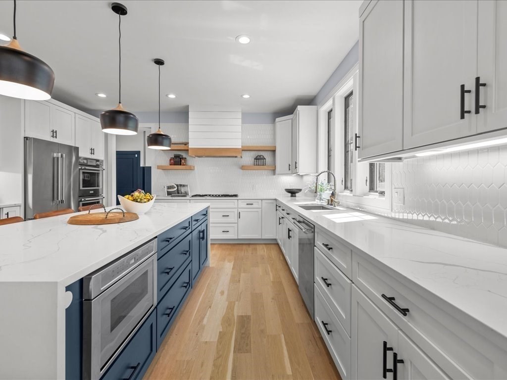 90 Norfolk Street Needham, MA 02492 - Photo 12 of 42 a large kitchen with stainless steel appliances kitchen island granite countertop a sink a stove and a refrigerator