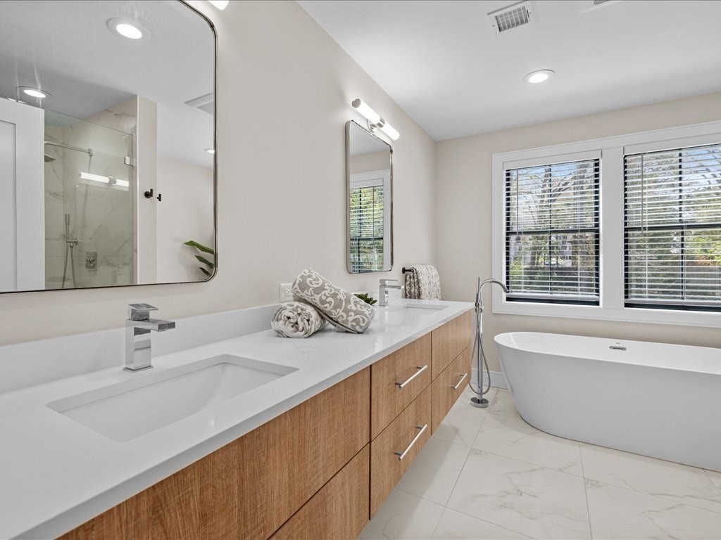 90 Norfolk Street Needham, MA 02492 - Photo 28 of 42 a bathroom with a double vanity sink window and a bathtub