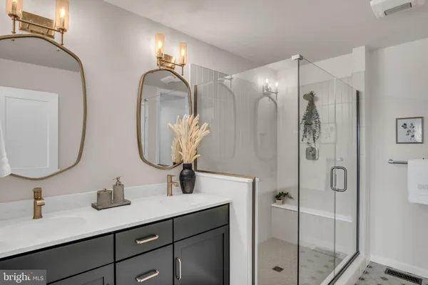 a bathroom with double vanity sinks and a mirror