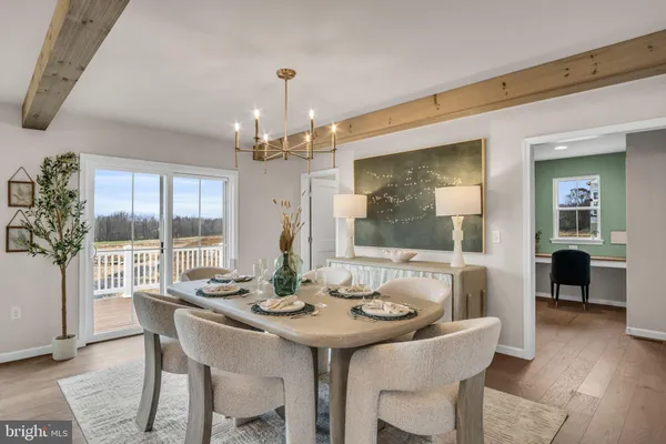 a dining room with furniture large windows and a chandelier