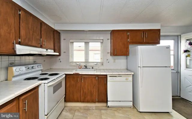 a kitchen with a white stove top oven and refrigerator