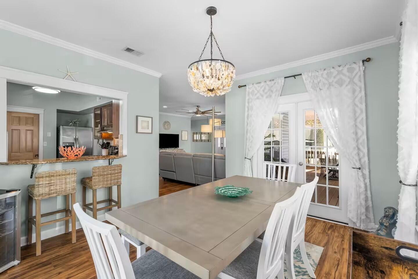 4503 John Avenue Destin, FL 32541 - Photo 11 of 51 a view of a dining room with furniture window and wooden floor