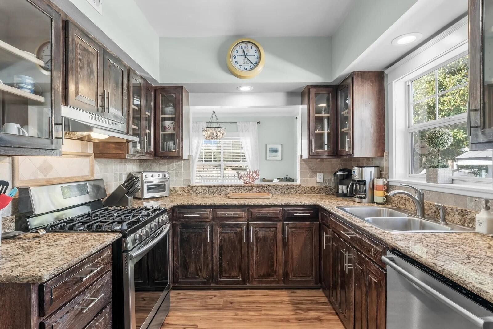 4503 John Avenue Destin, FL 32541 - Photo 13 of 51 a kitchen with stainless steel appliances granite countertop a sink stove and cabinets