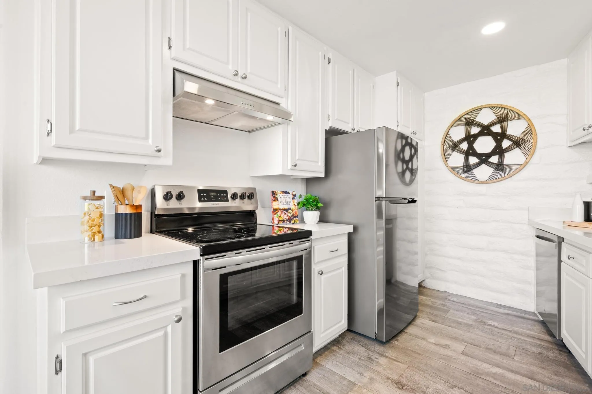 2544 Navarra Drive, Unit 17 Carlsbad, CA 92009 - Photo 17 of 24 a kitchen with stainless steel appliances white cabinets and a stove