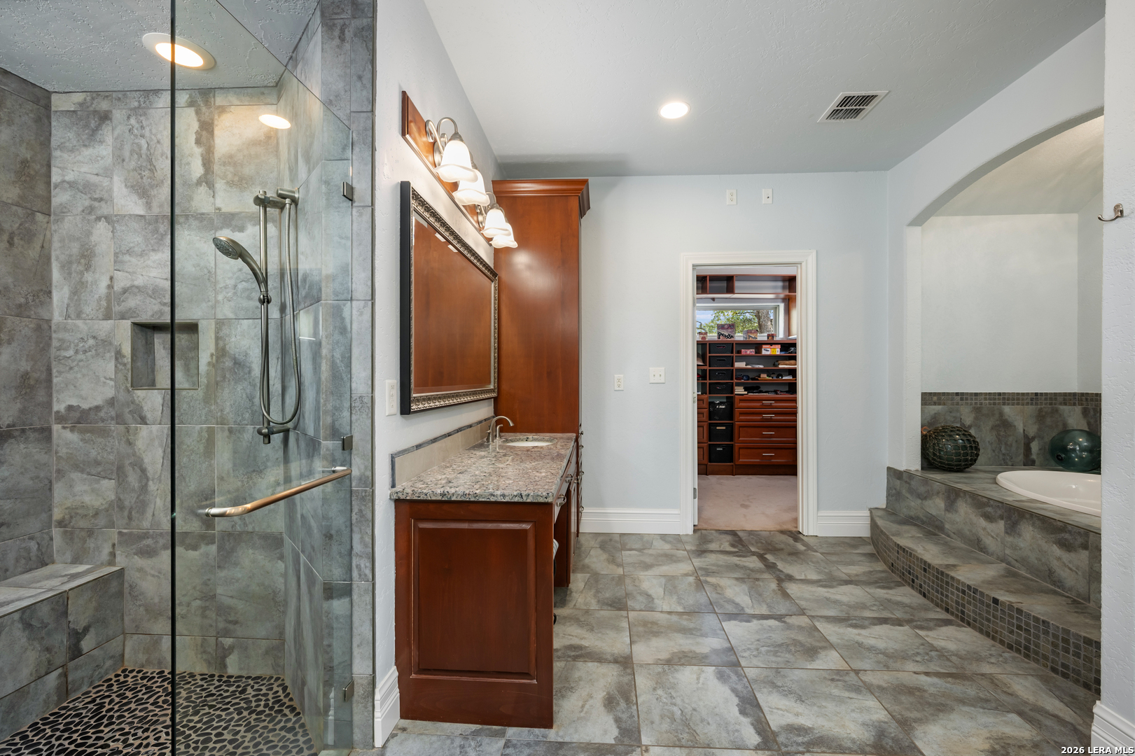 613 Saxet Trail Spring Branch, TX 78070 - Photo 23 of 50 a spacious bathroom with a granite countertop sink a mirror and shower