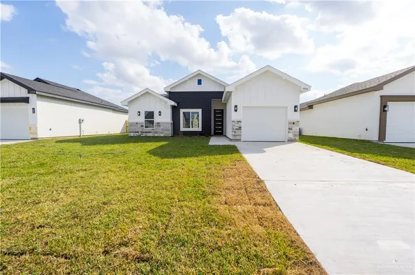 a view of a house with a yard and garage