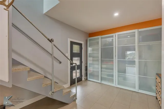 a spacious bathroom with a double vanity sink a toilet a mirror and shower