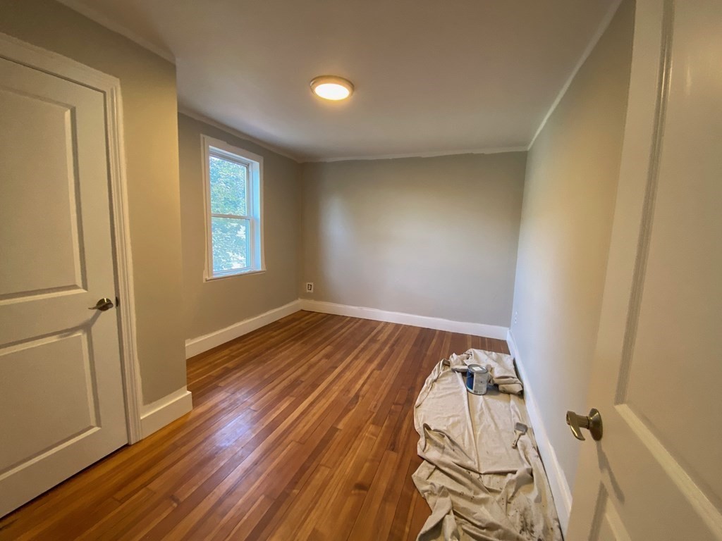 23 Main Street, Unit 2 Topsfield, MA 01983 - Photo 13 of 16 an empty room with wooden floor and windows