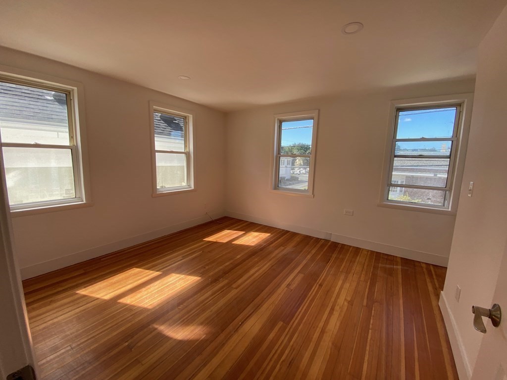 23 Main Street, Unit 2 Topsfield, MA 01983 - Photo 3 of 16 a view of empty room with wooden floor and fan