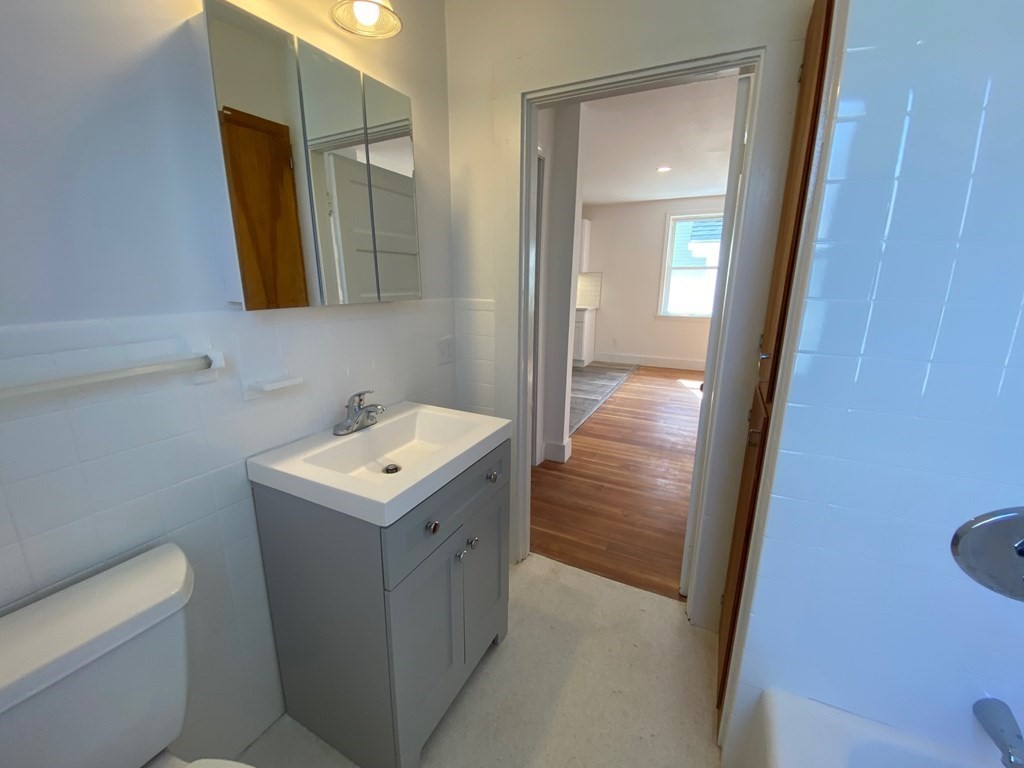 23 Main Street, Unit 2 Topsfield, MA 01983 - Photo 10 of 16 a bathroom with a sink a toilet and mirror
