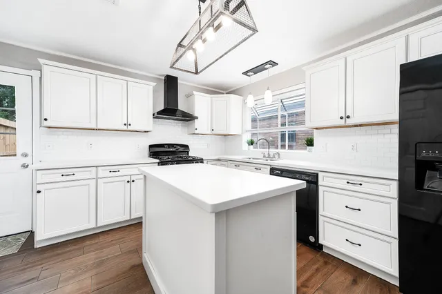 a kitchen with granite countertop white cabinets and white appliances