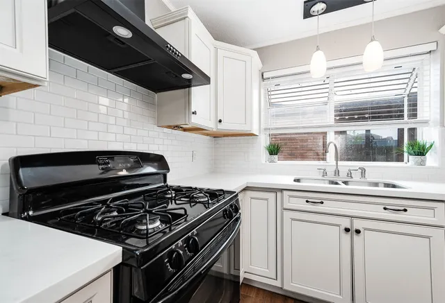a kitchen with granite countertop a stove sink and cabinets