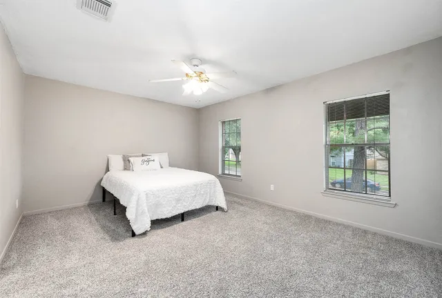 a spacious bedroom with a bed and a window