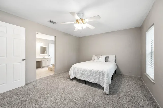 a spacious bedroom with a bed and a chandelier