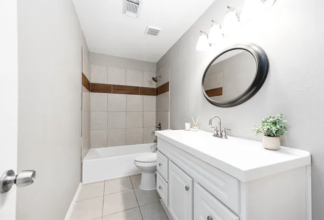 a bathroom with a sink a toilet and a mirror