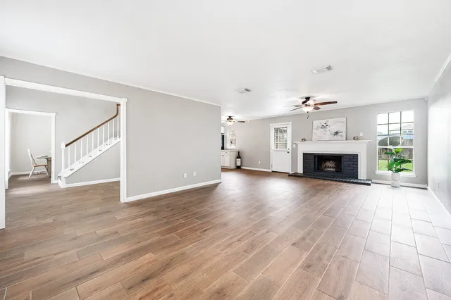 a view of empty room with wooden floor and fireplace