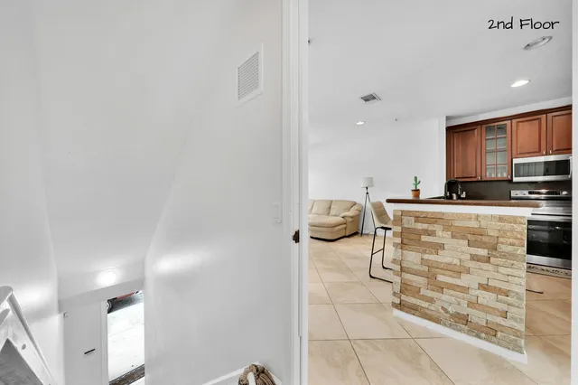 a kitchen with stainless steel appliances granite countertop a refrigerator a stove and a refrigerator with wooden floor