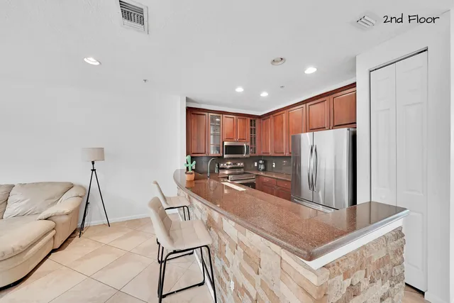 a kitchen with granite countertop a refrigerator and a stove top oven