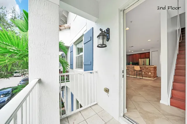 an empty room with wooden floor chandelier fan and windows