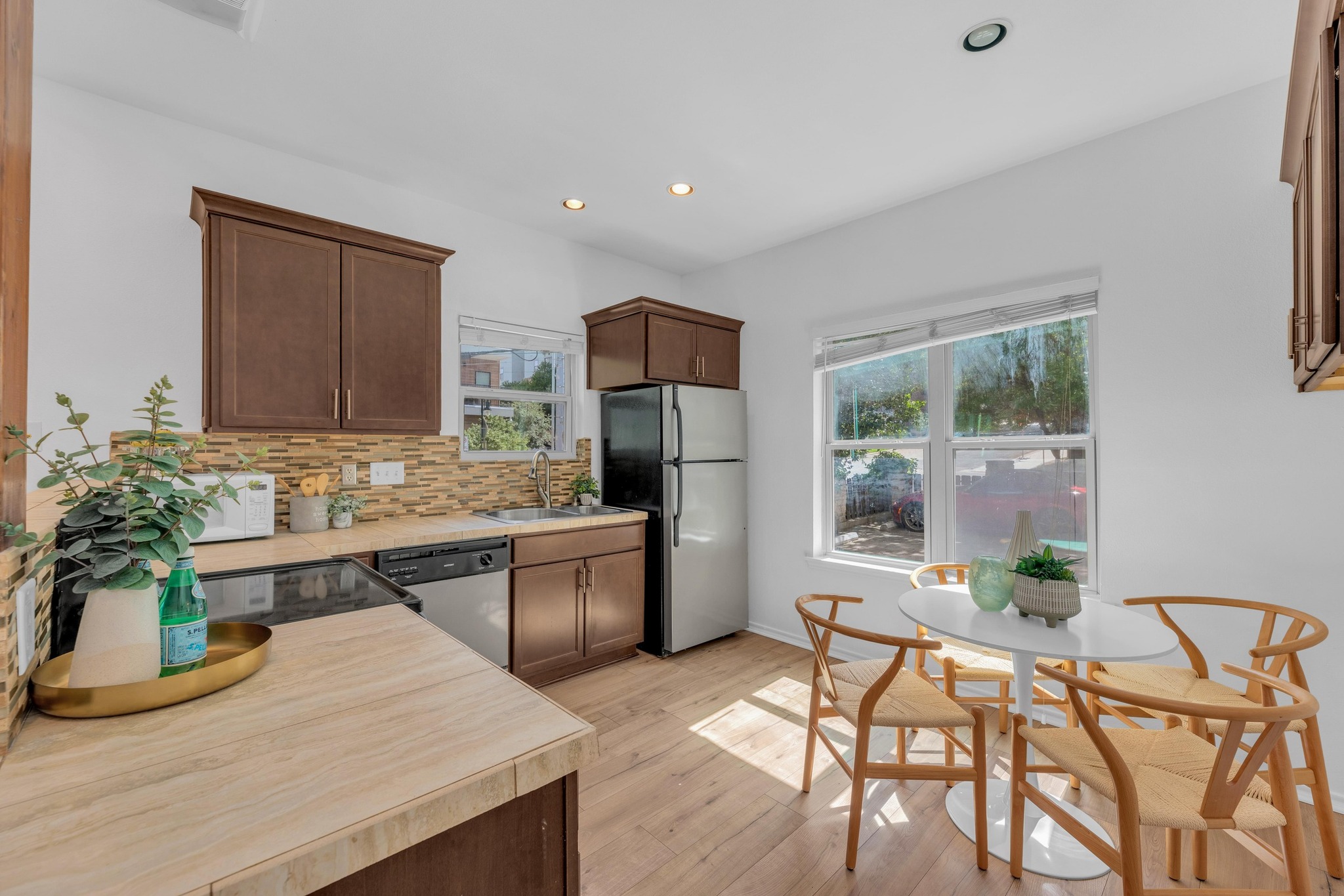 2414 Longview Street, Unit 101 Austin, TX 78705 - Photo 10 of 31 a kitchen with stainless steel appliances granite countertop a refrigerator a stove a sink dishwasher and white cabinets with wooden floor