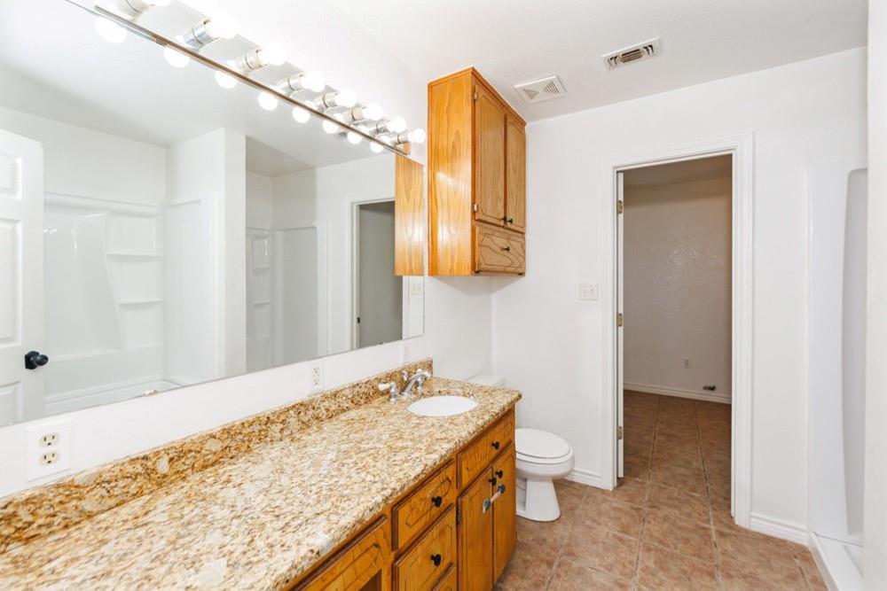 4316 Leona Road Bowie, TX 76230 - Photo 17 of 37 a bathroom with a granite countertop sink and a mirror